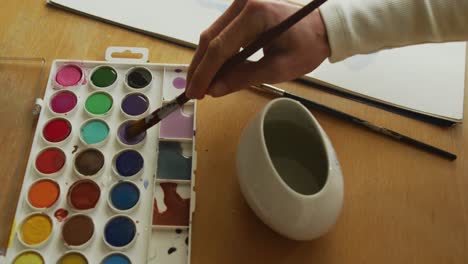 midsection of caucasian woman painting at home