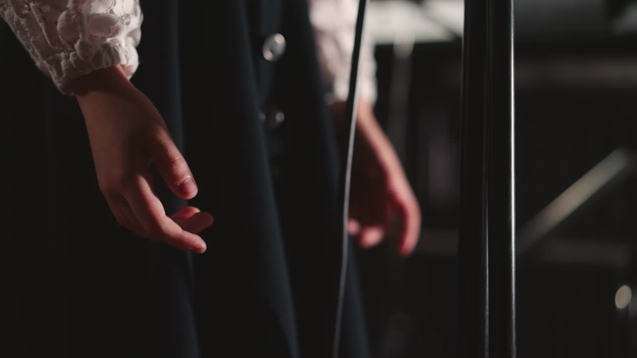 축제 드레스와 마이크를 입은 소녀가 무대 근접 촬영을 하고, 작은 가수가 휴일 콘서트에서 보컬을 연주하고, 아이가 학교에서 재능 쇼에 참여합니다.