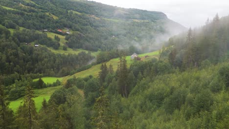 aerial view of picturesque mountain valley featuring a lush green forest with mist, scattered houses, and serene natural beauty, creating a tranquil atmosphere