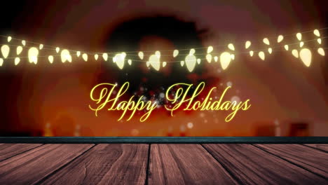 animation of fairy lights and happy holidays text over wooden boards