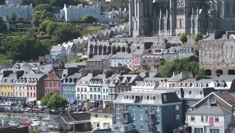 panorámica vertical cercana de la ciudad de cobh desde el agua con una fila de casas coloridas