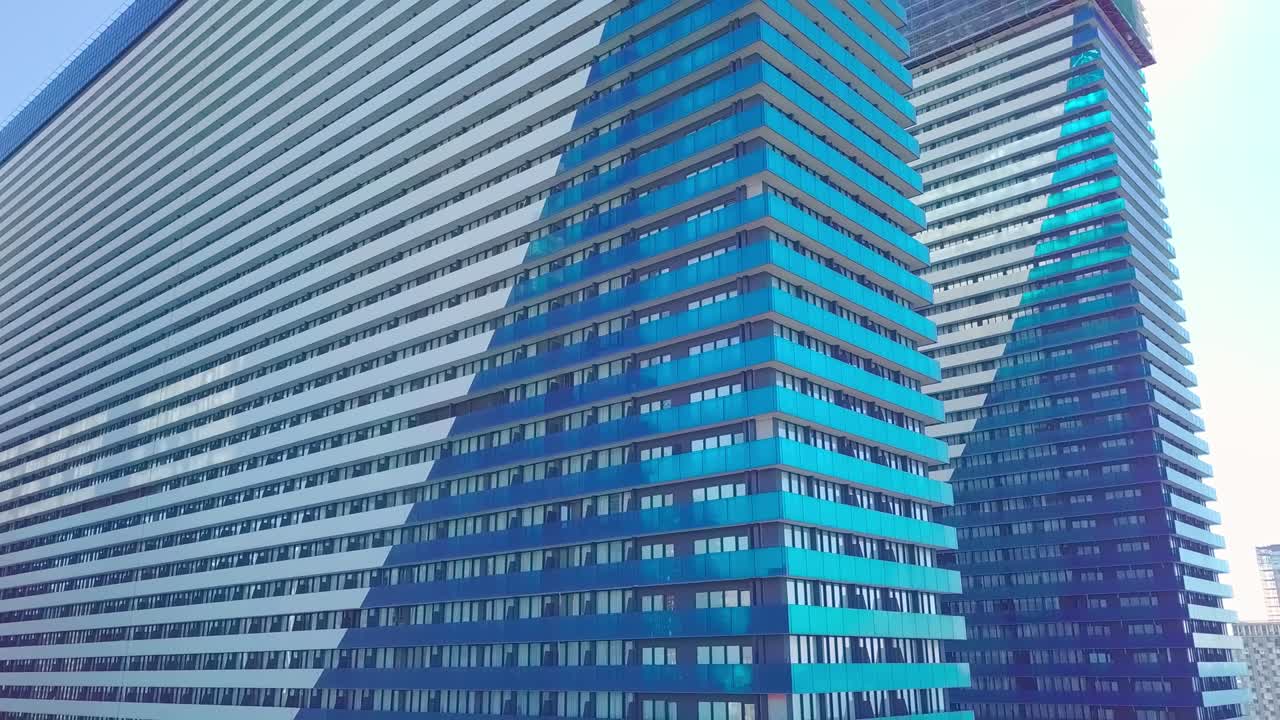 fotografia de reflexos do sol, das nuvens e do céu nas janelas de vidro do arranha-céu da cidade.