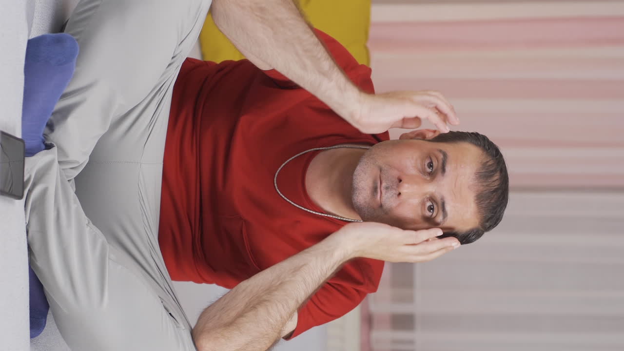 Vertical video of Man looking thoughtfully at camera.