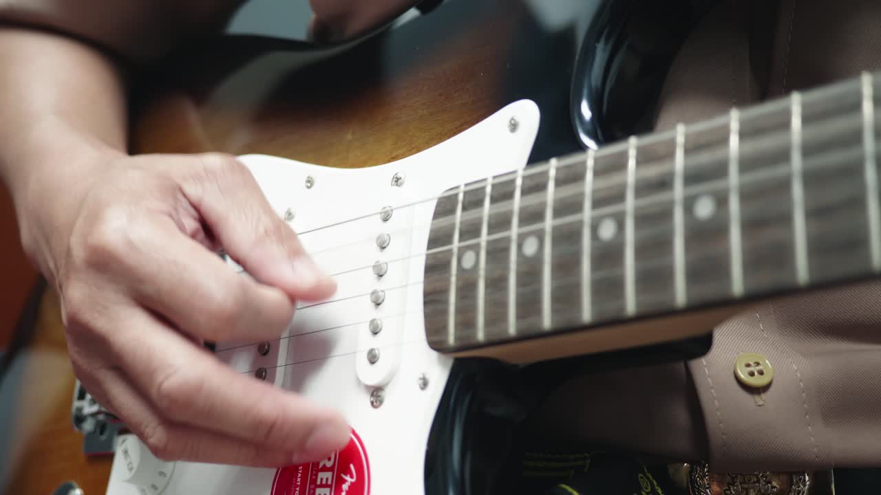 el primer plano de un hombre practicando tocar la guitarra tiene una hermosa escena.