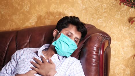 man sleeping on couch wearing a mask