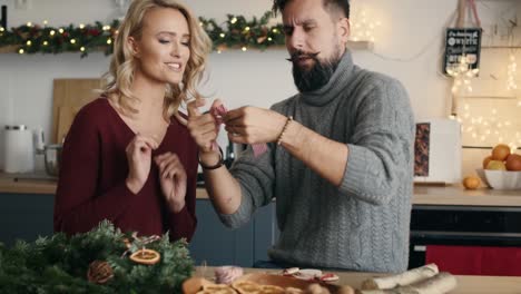 mujer rubia enseñando a los hombres cómo hacer el arco de navidad