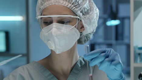 Female-Lab-Worker-in-Mask-Pouring-Liquid-in-Test-Tube