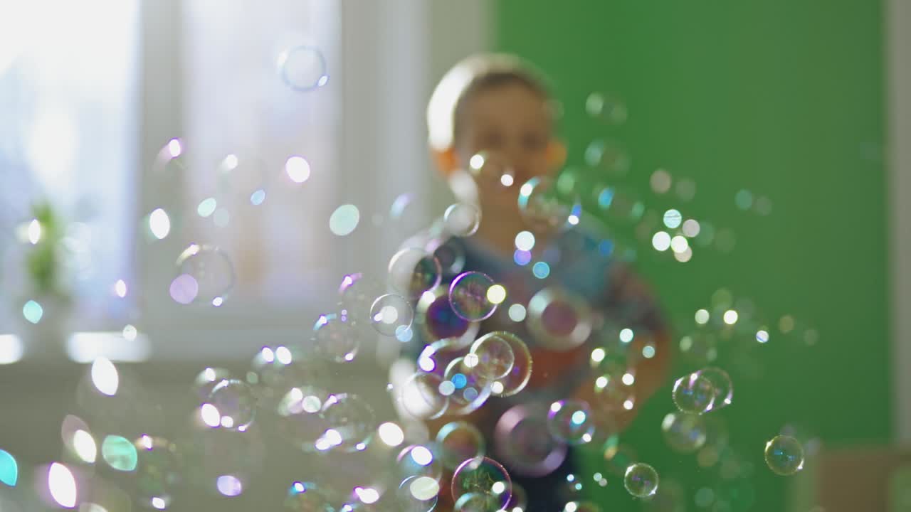 Soap bubbles background. Boy playing with soap bubbles