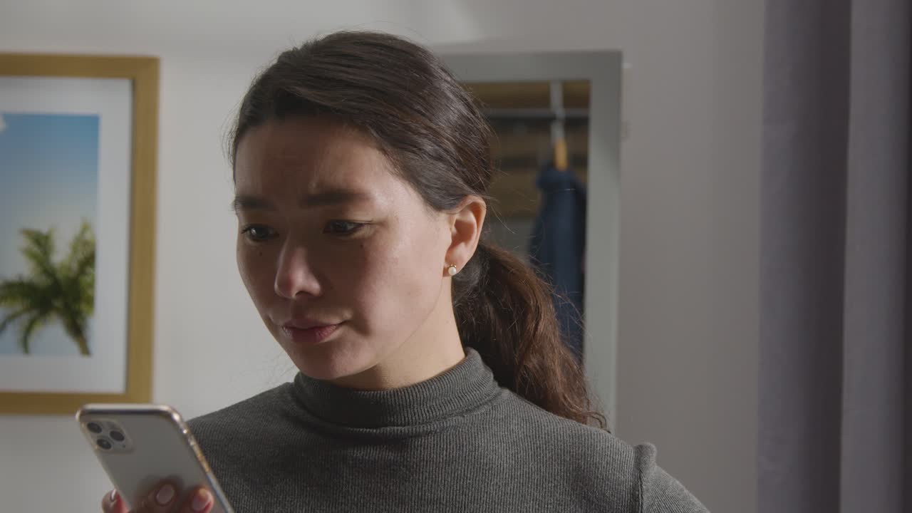 집에서 실망한 여자가 취업 면접에 실패했다는 문자 메시지를 받고 있다 1