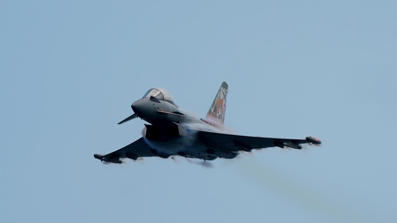 Fighter jet flying away with wing pylons