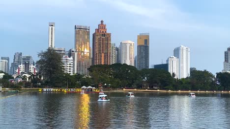 los barcos se deslizan en el estanque con el horizonte de la ciudad