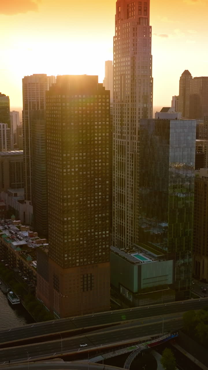 Bright sun shining over the gorgeous Chicago, Illinois, USA. Marvelous skyscrapers in the rays of setting sun. Top view. Vertical video