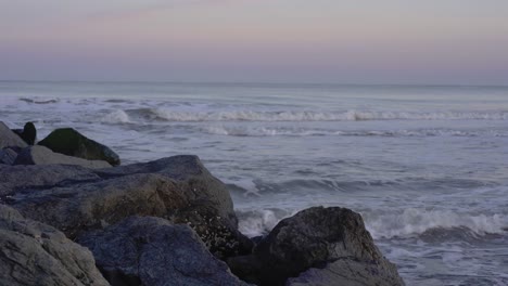 Blaue-Stunde-Mit-Rosafarbenem-Himmel-Am-Strand-Mit-Felsen-In-Ocean-City,-New-Jersey