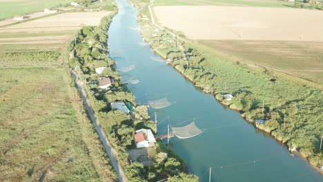 Aerial-view-of-fishing-huts-in-the-river,-Lido-di-Dante,-Fiumi-Uniti,-Ravenna-near-Comacchio-valley