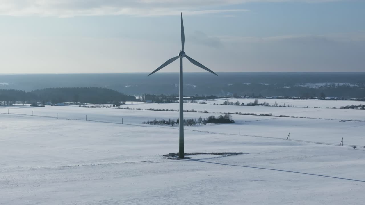 멀리 떨어진 나무와 이 있는 눈 인 풍력 터빈