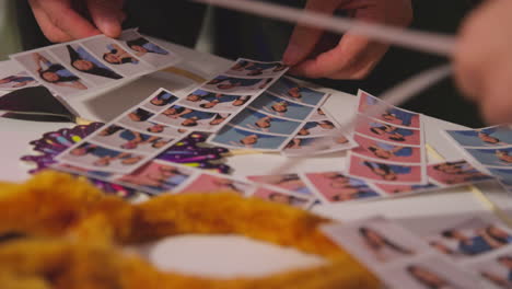 close up of a group of friends having fun looking at prints from photo booth with props