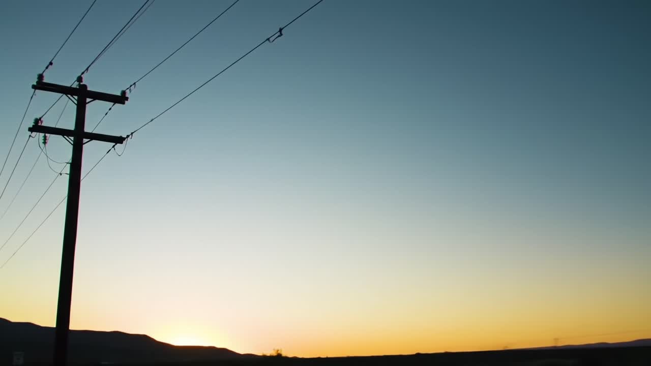 Serene Landscape at Dusk: A Beautiful Transition from Day to Night Showcasing Power Lines Against a Gradient Sky with a Setting Sun on the Horizon