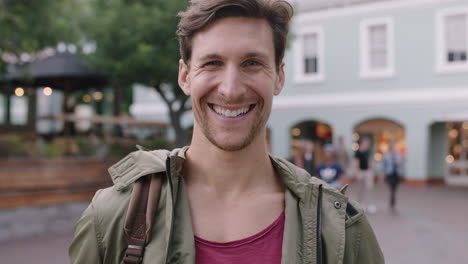 retrato de un joven guapo que se ríe alegremente en el fondo urbano de la cámara