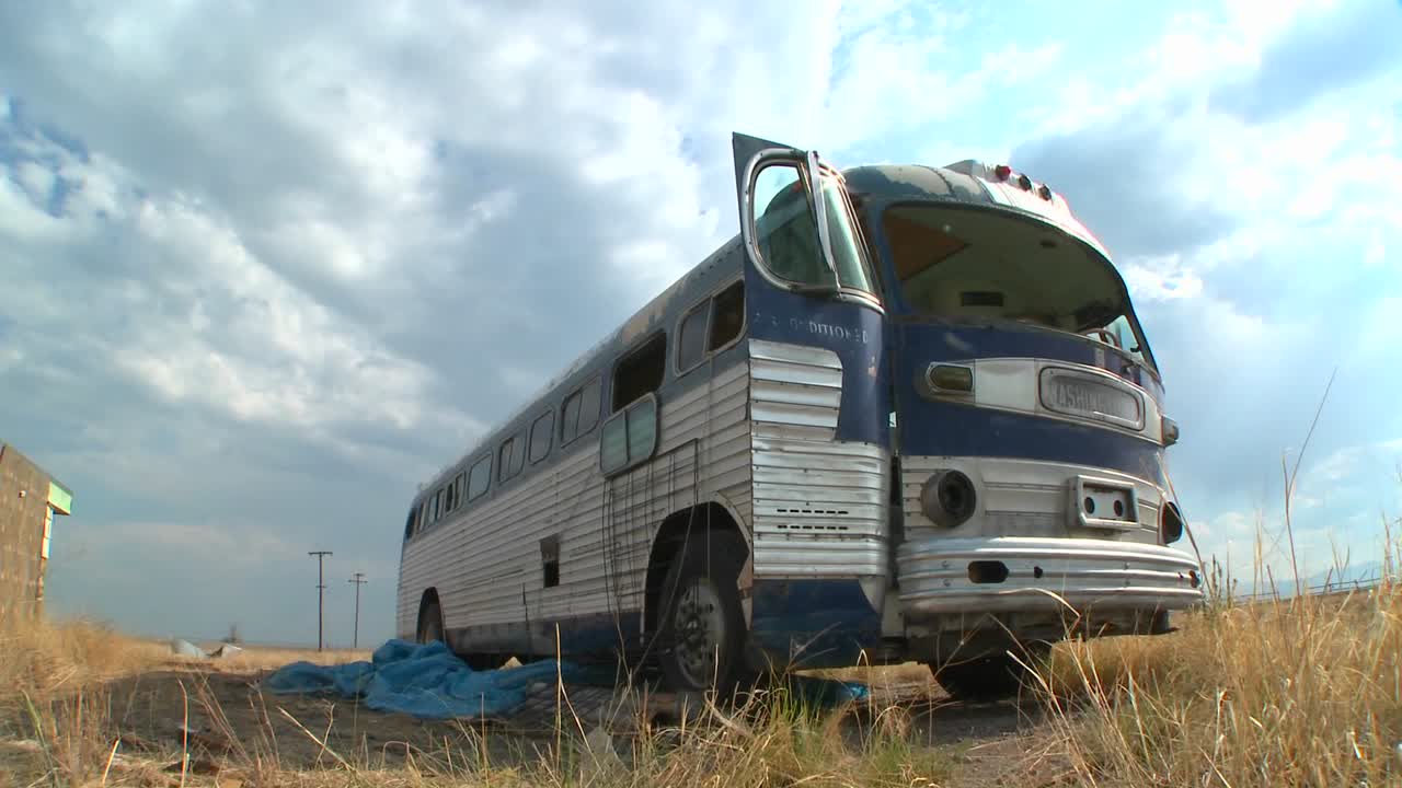들판에 버려진 그레이하운드 버스의 움직이는 저속 촬영