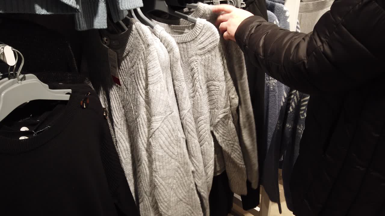 L'acquirente sceglie un maglione nel centro commerciale.