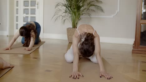 mujeres practicando yoga en casa