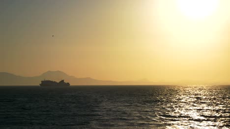 A-ferry-sailing-on-the-Greek-waters-of-the-Ionian-Sea,-all-in-the-rays-of-the-setting-sun