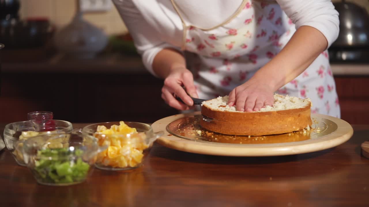 mujer cortando un pastel de capa en la cocina