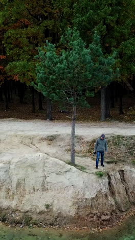 photographer working on shore. aerial view of photographer taking photo of nature on lake shore vertical video