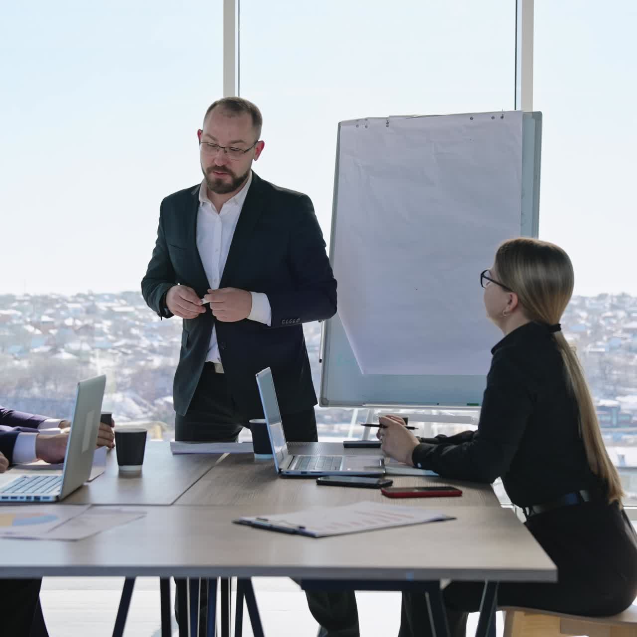 Businesspeople having discussion in the meeting at office. Middle-aged male manager performs presentation for colleagues