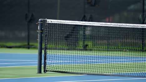 panning close-up of blue tennis net on court