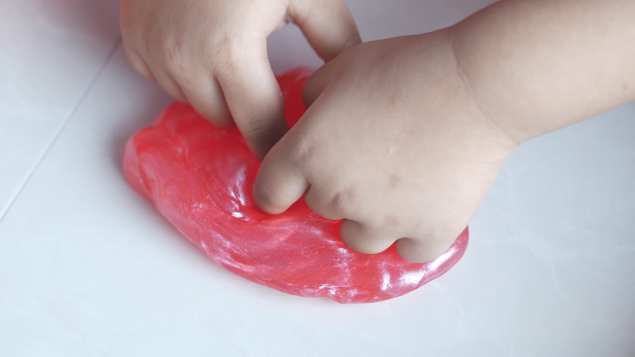 la mano del niño sosteniendo limo rosado