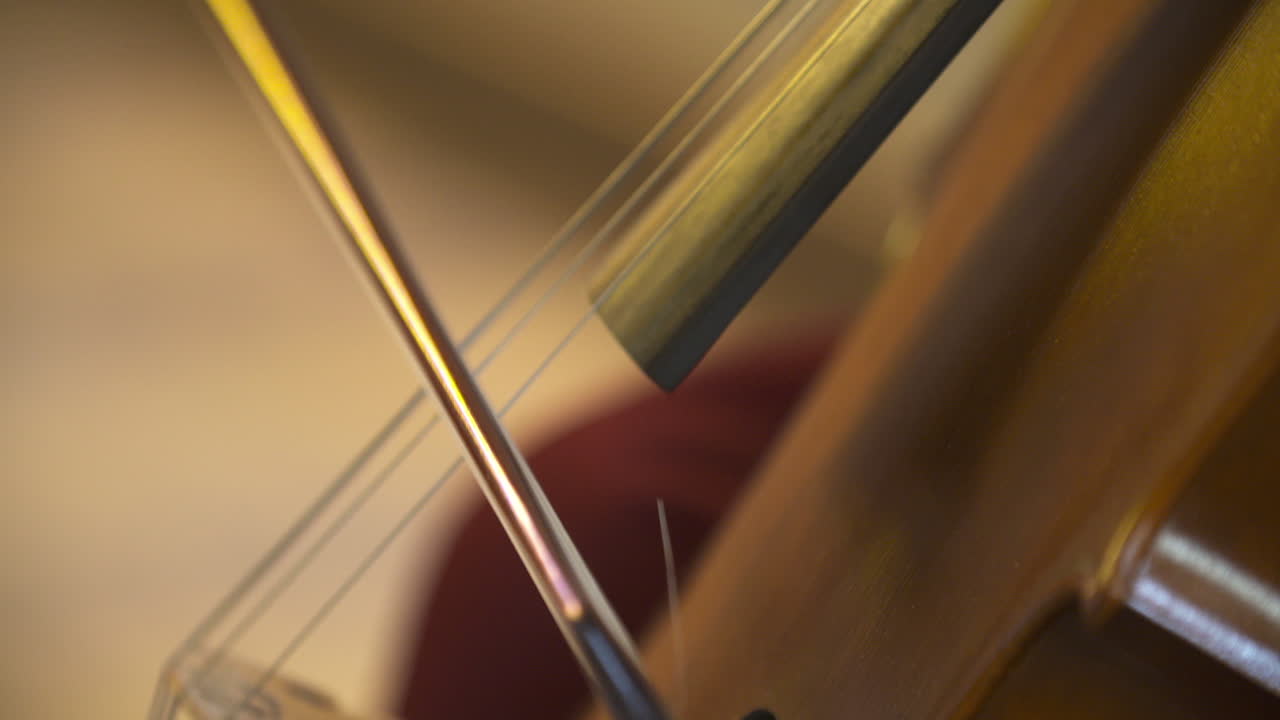 Primo piano di un musicista che suona il violoncello con un archetto