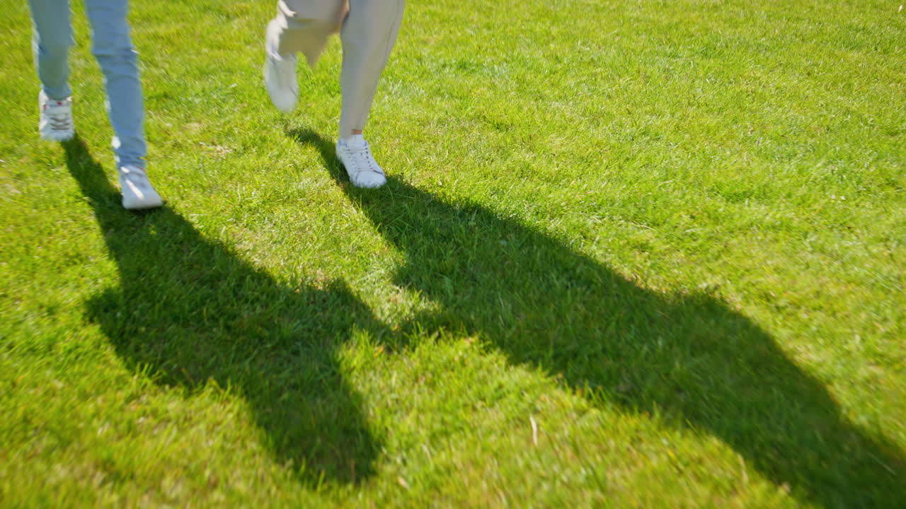 Daughter mother legs walking sunlight green zone closeup. Woman pointing finger