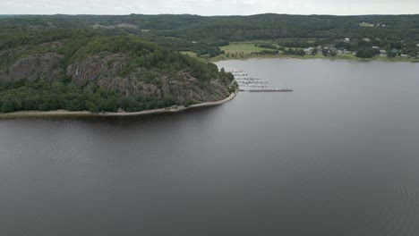 aerial flight to small marina on nordic lake in swedish countryside