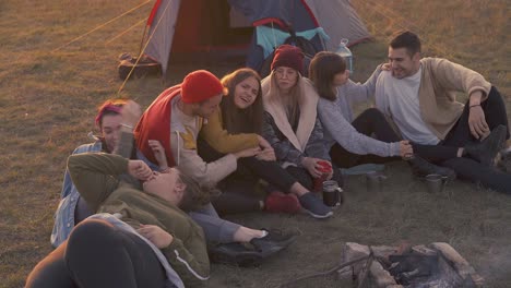 los turistas positivos descansan en la hoguera en el campamento por la noche