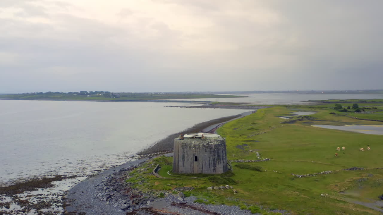Establishing aerial shot of Aughinish Martello Tower and its narrow causeway linking to the mainland in Galway Bay