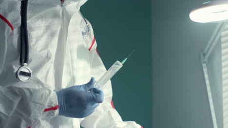 doctor draw medical syringe using drip bag in hospital infectious disease unit.