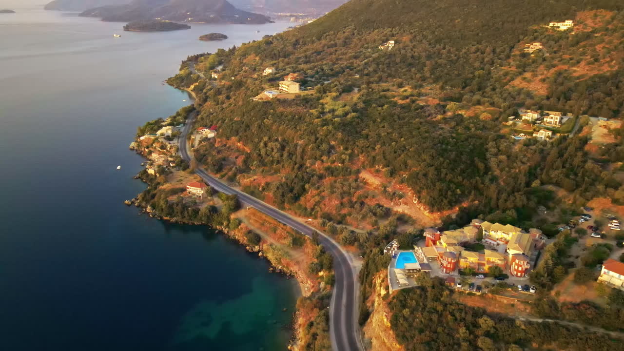 Aerial drone view of a town on Zakynthos at sunset, Greece. Buildings and greenery, road, Ionian sea coast