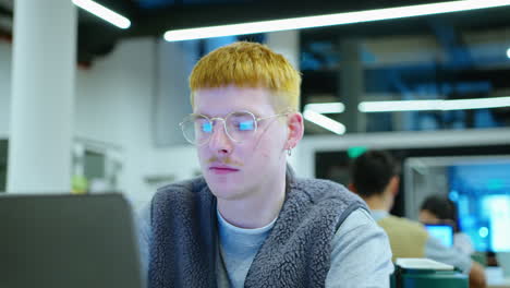 cheerful gen z man using laptop while working in the office