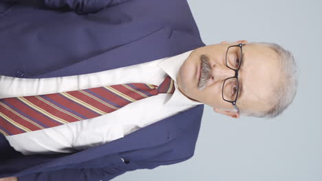 vídeo vertical del curioso viejo hombre de negocios.