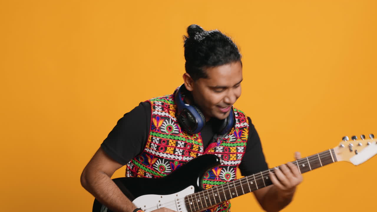 Uomo felice che tiene una chitarra elettrica, suona musica rock, su sfondo in studio