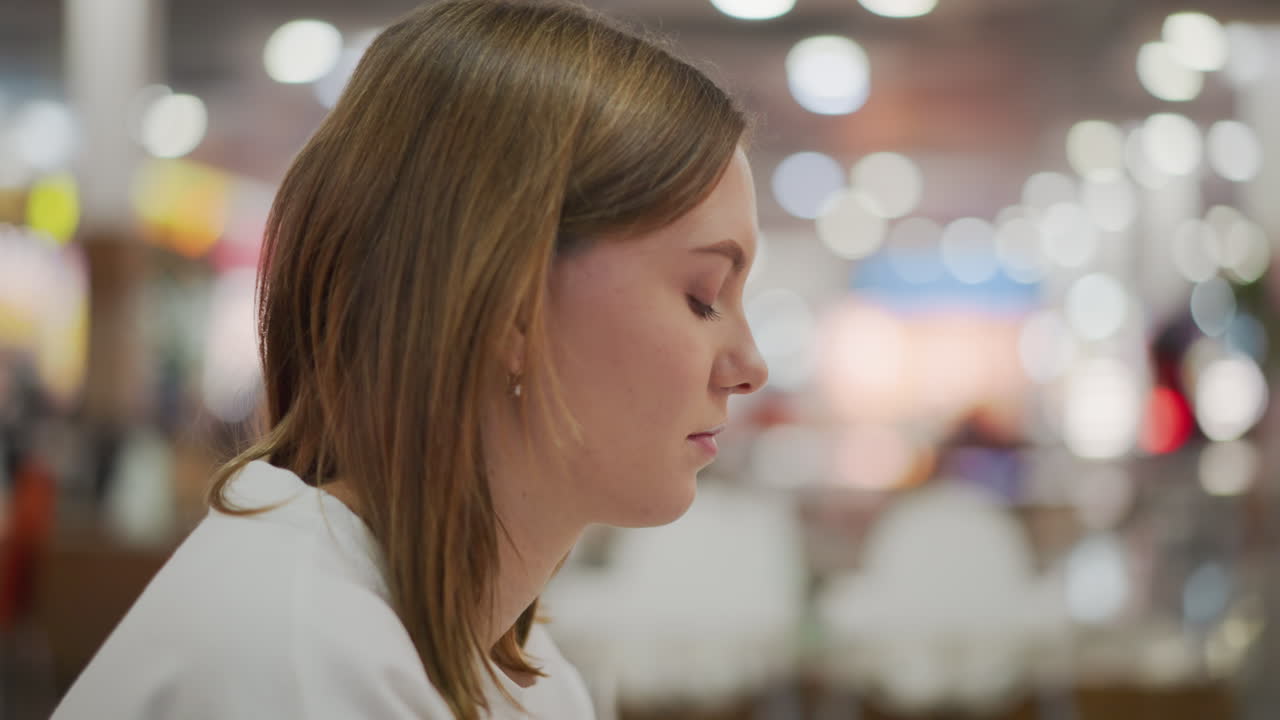 крупный план молодой женщины, глубоко сосредоточенной, излучающей концентрацию и профессионализм в яркой, современной внутренней среде с размытым красочным фоном