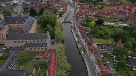 Aerial-shot-of-Bruges-in-Belgium-overlooking-a-canal-and-it's-old-houses-and-buildings