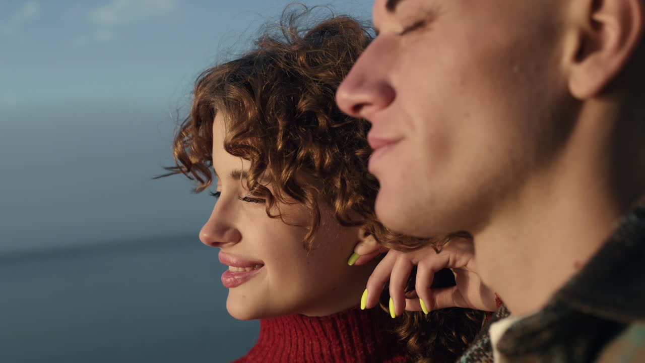 Pareja joven disfrutando la última luz del atardecer en la playa. Mujer y hombre posando para la cámara.