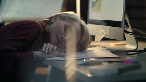 Exhausted-business-woman-lying-down-on-table-at-night