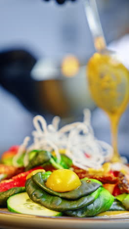 ready-made dish of fresh vegetables. close up. hands of a cook pour some sauce on top of the salad. vertical video.