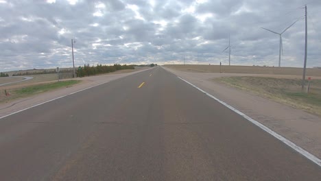 Fahrt-Auf-Einer-Ruhigen-Autobahn-Vorbei-An-Windkraftanlagen-Im-Ländlichen-Süden-Von-Nebraska-An-Einem-Bewölkten-Tag-Im-Frühjahr