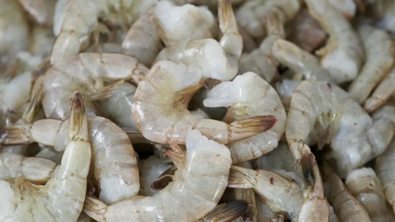 많은 원시 새우가 큰 그에 놓여 있습니다.