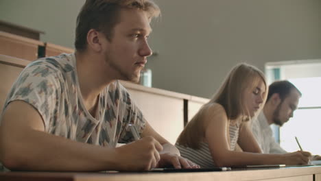 The-camera-moves-through-the-class-between-the-rows.-University-production-a-large-audience-students-write-in-the-lecture-notebooks-and-laptops.