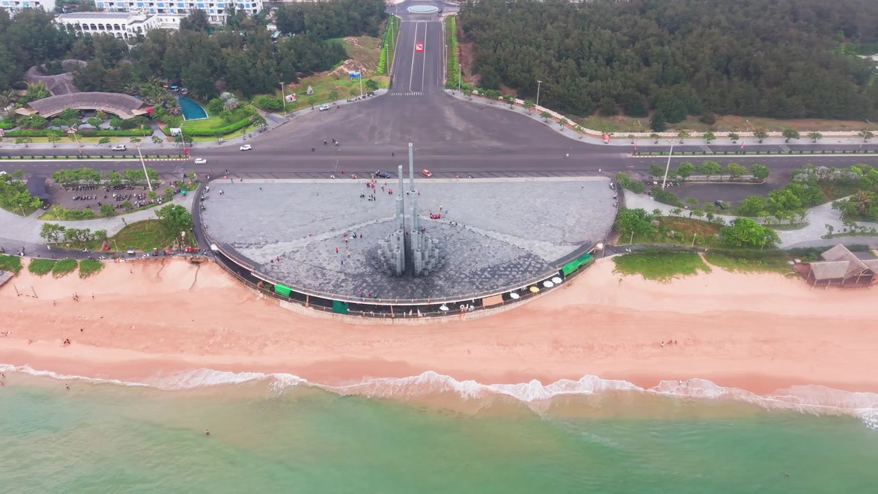 Bãi biển Tuy Hòa ở Việt Nam hiện ra một bãi cát rộng và những con sóng biển. Mọi người đi dạo dọc theo lối đi và thư giãn bên bờ biển. Mặt trời chiếu sáng rực rỡ trên bầu trời.